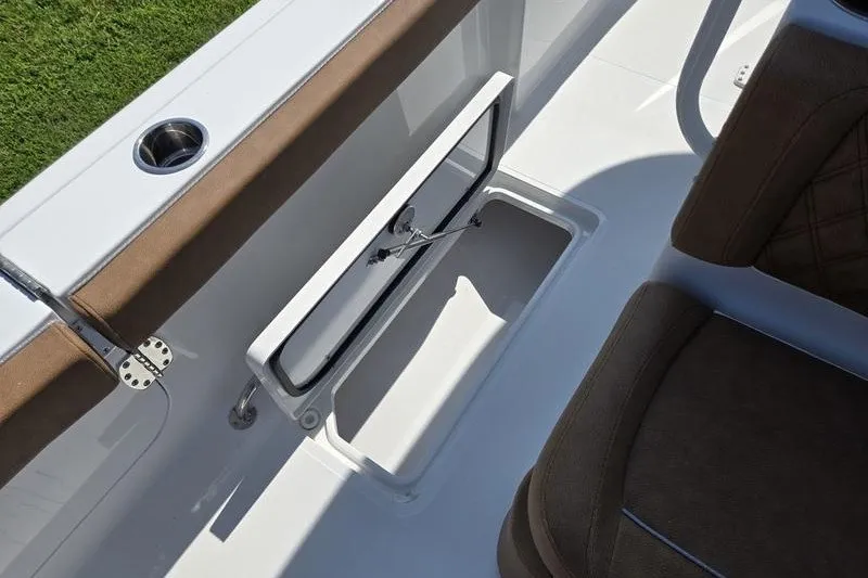 Slide: The Image of 2027 Sea Hunt Ultra 275SE boat interior with open storage compartment and cushioned seating. - 17