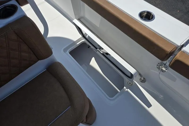 Slide: The Image of Interior view of 2027 Sea Hunt Ultra 275SE boat, featuring brown seating and storage compartment. - 14