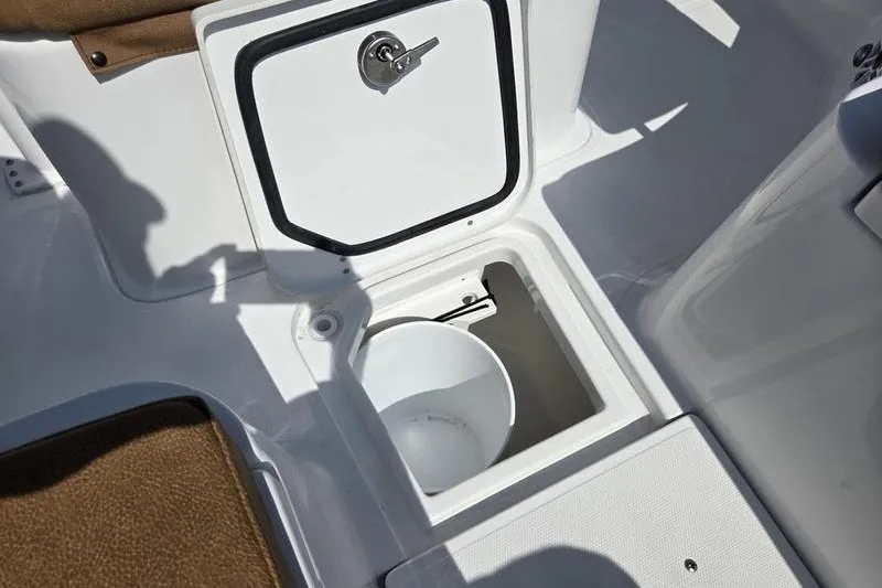 Slide: The Image of Storage compartment on 2027 Sea Hunt Ultra 275SE boat with white bucket inside. - 16