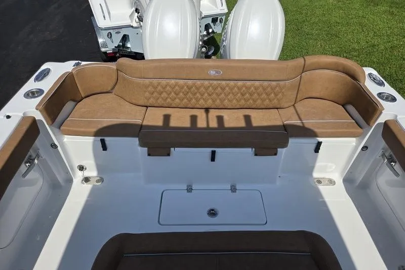 Slide: The Image of 2027 Sea Hunt Ultra 275SE boat interior with tan cushioned seating and dual engines. - 20