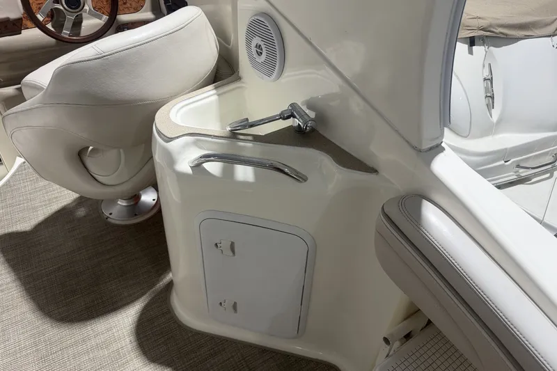 Slide: The Image of 2006 Larson Cabrio 260 boat interior with sink and seating area. - 13