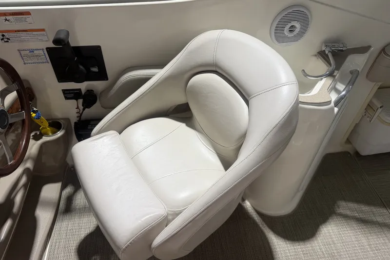Slide: The Image of Captain's seat in 2006 Larson Cabrio 260 boat cockpit, featuring steering wheel and controls. - 11