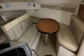 Slide: The Image of 2006 Larson Cabrio 260 cabin interior with seating and wooden table. - 26