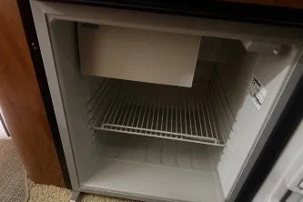 Slide: The Image of Empty refrigerator inside a 2006 Larson Cabrio 260 boat cabin. - 30