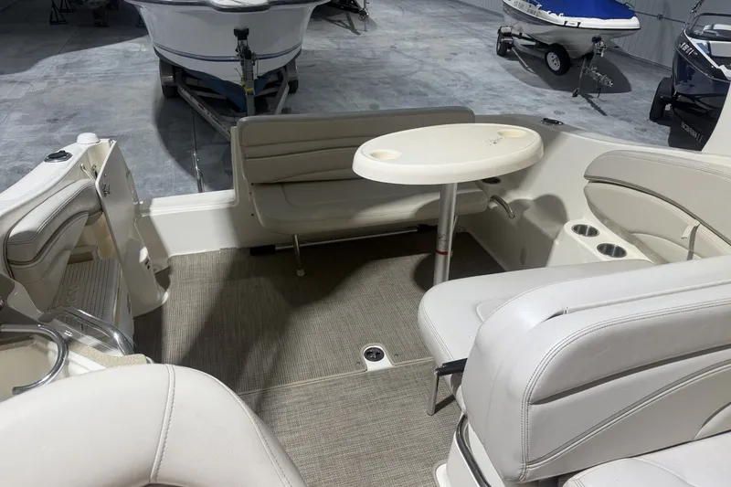 Slide: The Image of 2006 Larson Cabrio 260 boat interior with seating and table in a showroom. - 19