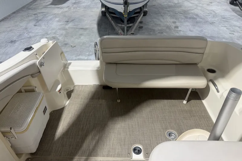Slide: The Image of 2006 Larson Cabrio 260 boat interior with beige seating and carpeted floor. - 9