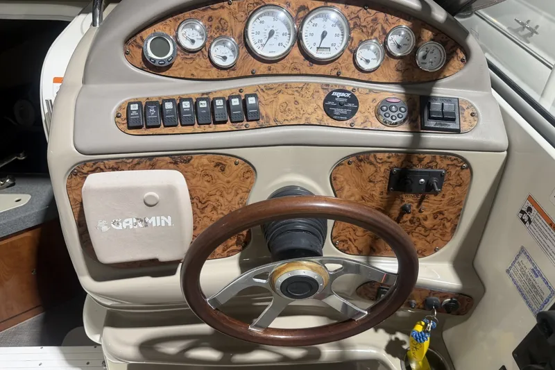 Slide: The Image of 2006 Larson Cabrio 260 dashboard with wood accents, gauges, and Garmin navigation system. - 15