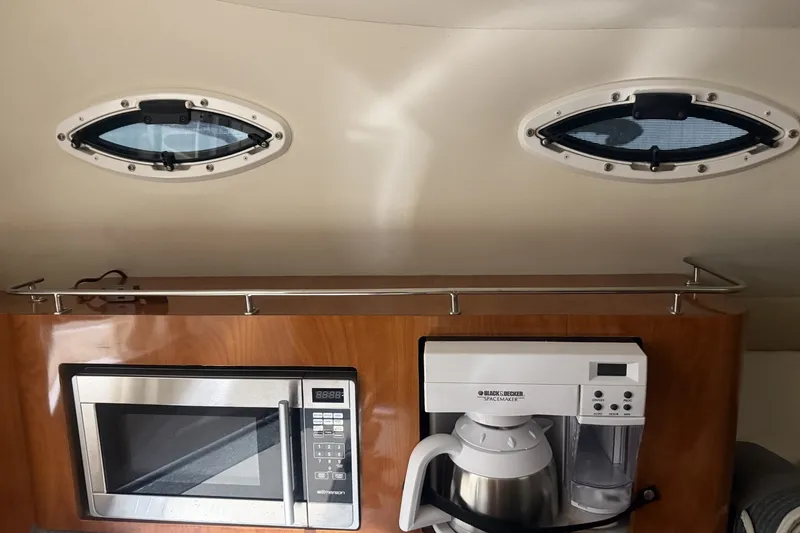 Slide: The Image of 2006 Larson Cabrio 260 interior with microwave and coffee maker under portholes. - 37
