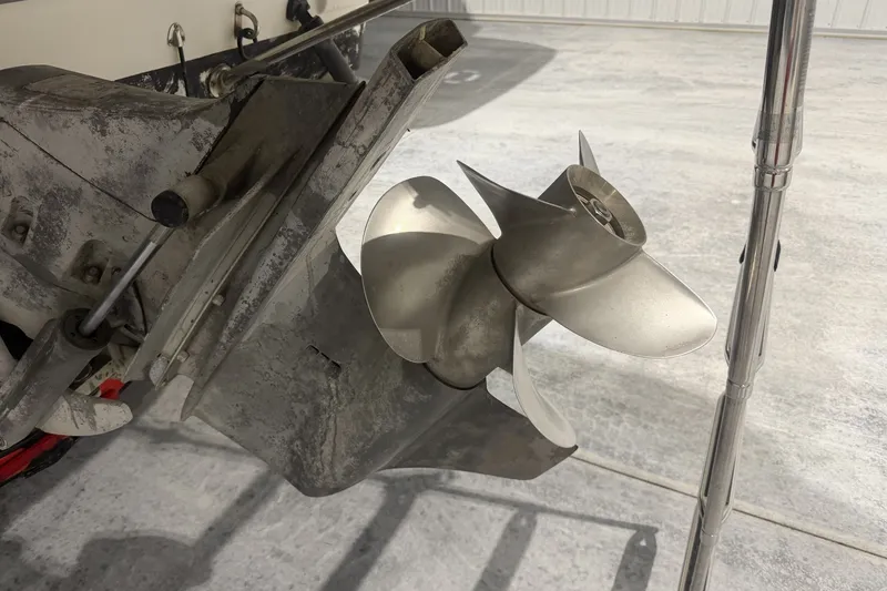 Slide: The Image of 2006 Larson Cabrio 260 boat propeller and outdrive in a garage setting. - 8