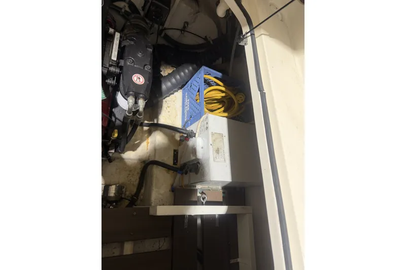 Slide: The Image of Engine compartment of a 2006 Larson Cabrio 260 boat, featuring mechanical components and wiring. - 38