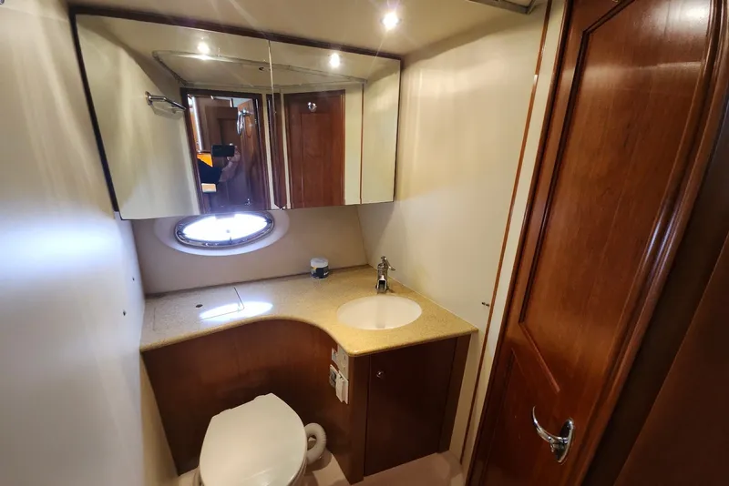 Slide: The Image of Bathroom interior of 2008 Silverton 36 Convertible yacht with wooden cabinetry and round window. - 26