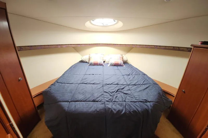 Slide: The Image of Interior cabin of 2008 Silverton 36 Convertible yacht with cozy bed and wooden cabinets. - 25