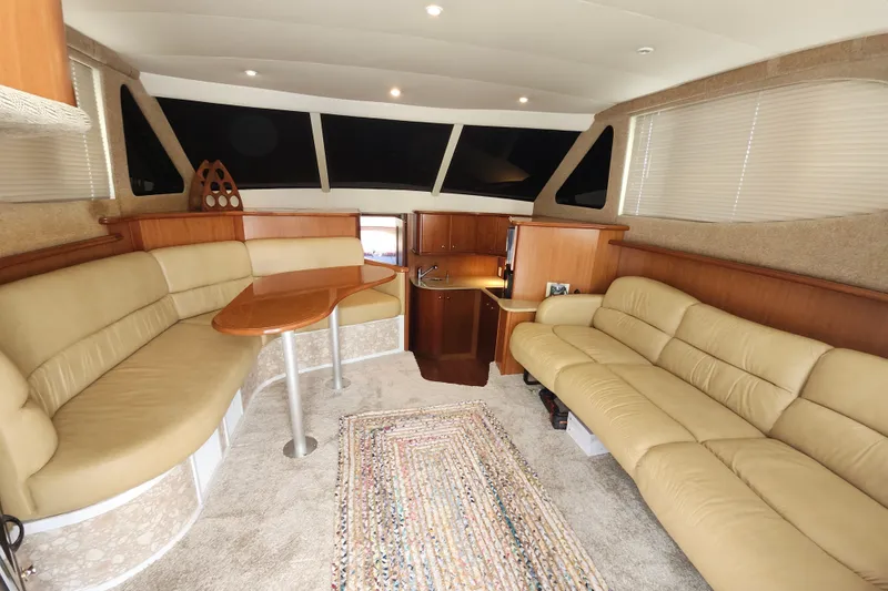 Slide: The Image of Luxurious interior of 2008 Silverton 36 Convertible yacht with beige seating and wooden accents. - 19