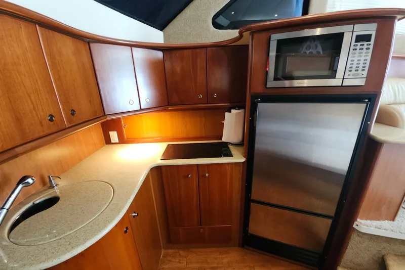 Slide: The Image of Luxurious 2008 Silverton 36 Convertible yacht kitchen with wood cabinetry and modern appliances. - 24
