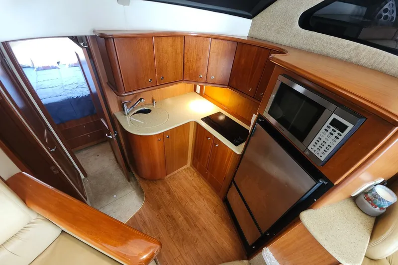 Slide: The Image of 2008 Silverton 36 Convertible yacht kitchen with wood cabinetry, microwave, and compact appliances. - 23