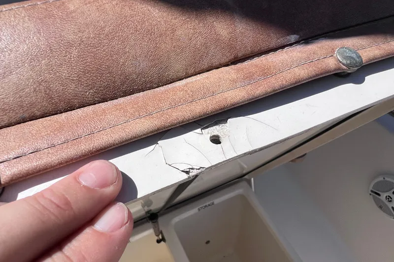 Slide: The Image of Cracked seat base on 2012 Scout 210 XSF boat, showing upholstery and damage. - 42