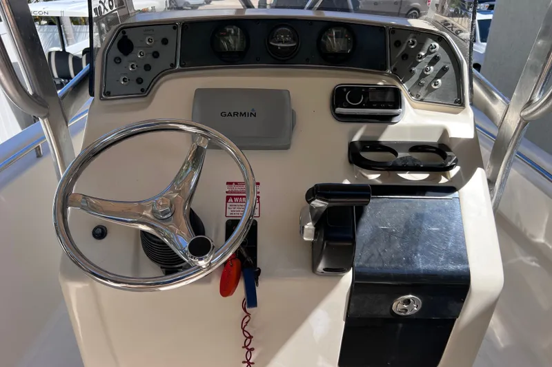 Slide: The Image of 2012 Scout 210 XSF boat dashboard with steering wheel and Garmin navigation system. - 22