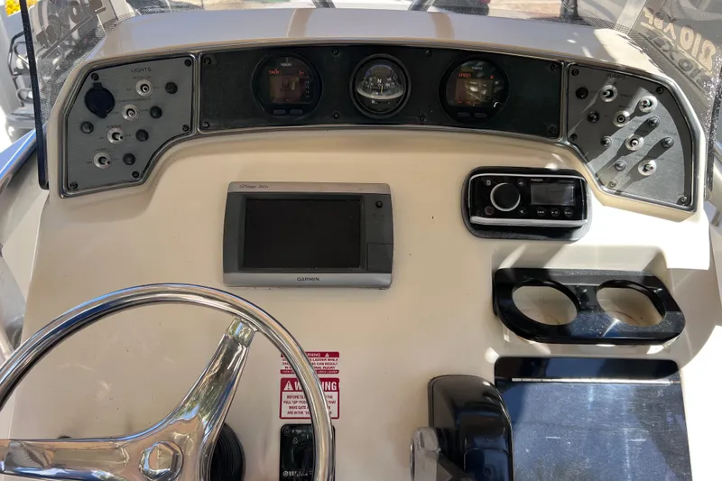 Slide: The Image of Control panel of a 2012 Scout 210 XSF boat with Garmin GPS and steering wheel. - 27