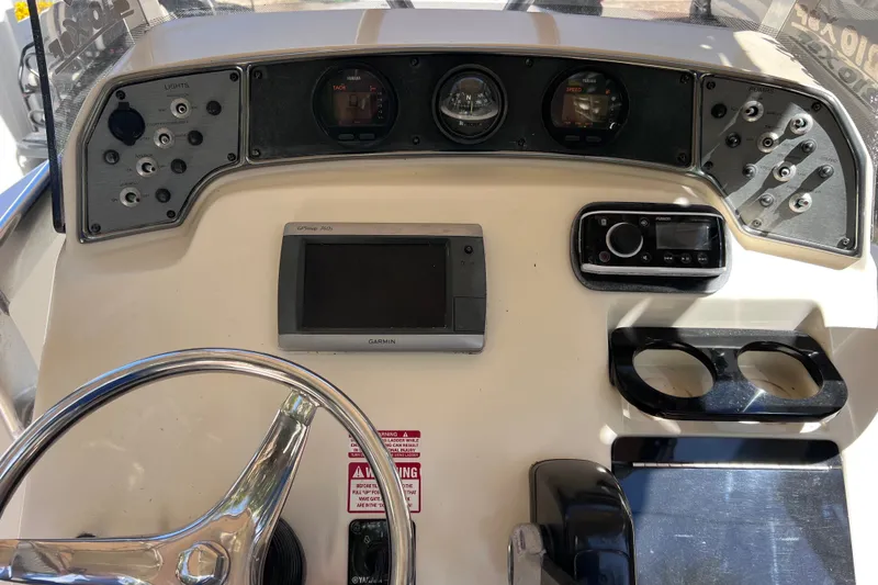 Slide: The Image of 2012 Scout 210 XSF boat dashboard with Garmin GPS, steering wheel, and control panel. - 28