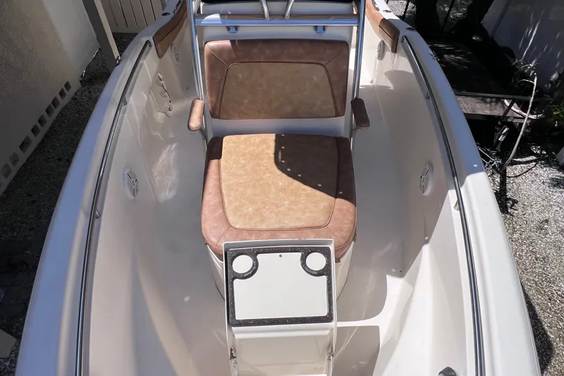 Slide: The Image of 2012 Scout 210 XSF boat interior with tan seating and white deck. - 44