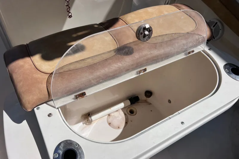 Slide: The Image of Open storage compartment on a 2012 Scout 210 XSF boat with cushioned seat. - 23