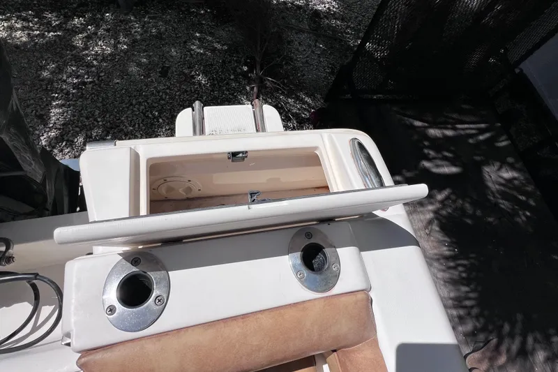 Slide: The Image of 2012 Scout 210 XSF boat interior with rod holders and storage compartment. - 16