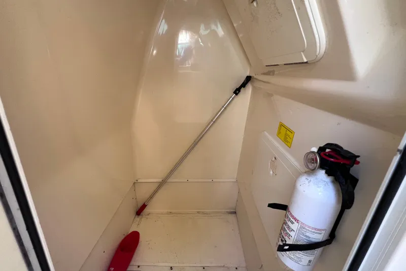 Slide: The Image of Storage compartment of a 2012 Scout 210 XSF boat with fire extinguisher and paddle. - 47