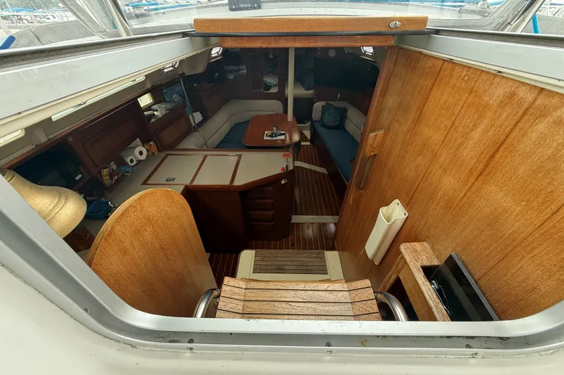Slide: The Image of Interior view of 1996 Hunter Legend 37.5 sailboat, featuring wooden furnishings and cozy seating area. - 12
