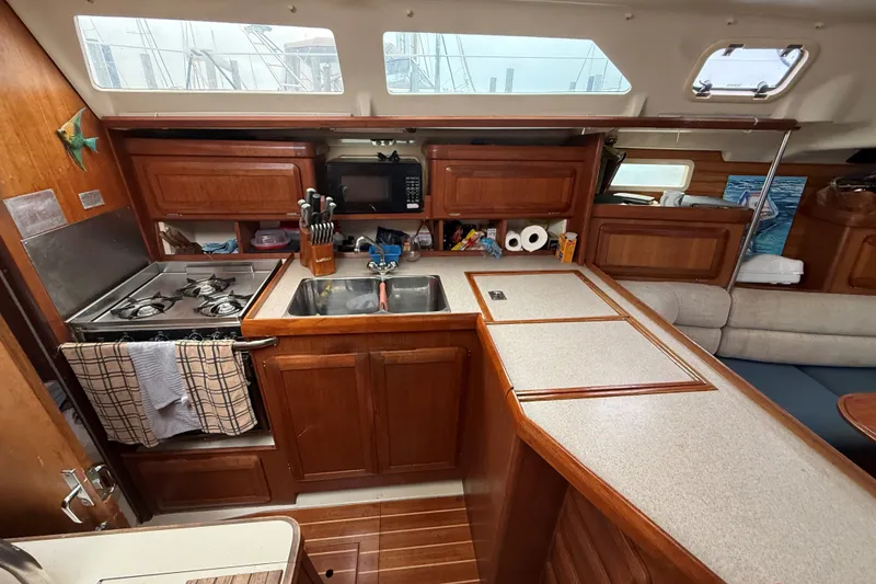 Slide: The Image of Interior of a 1996 Hunter Legend 37.5 sailboat kitchen with stove, sink, and wooden cabinetry. - 15