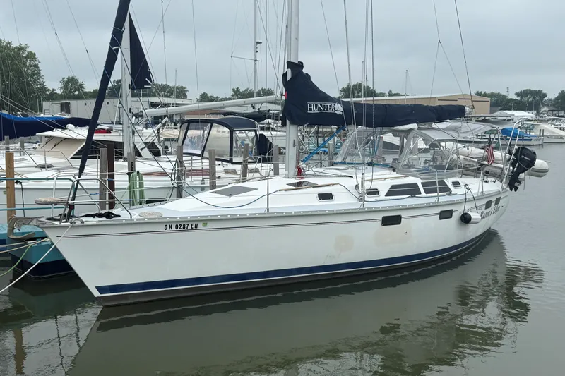 The Image of 1996 Hunter Legend 37.5 sailboat docked in a marina, featuring sleek design and white hull. - 1