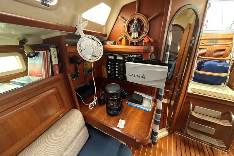 Slide: The Image of 1996 Hunter Legend 37.5 yacht interior with navigation equipment, books, and wooden cabinetry. - 19