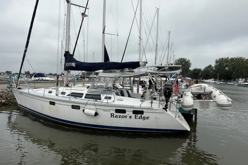 Slide: The Image of 1996 Hunter Legend 37.5 sailboat named "Razor's Edge" docked in a marina. - 3