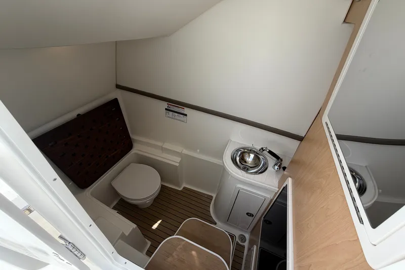 Slide: The Image of 2027 World Cat 325 DC boat bathroom with toilet, sink, and wooden flooring. - 15