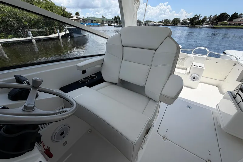 Slide: The Image of Captain's seat on 2027 World Cat 325 DC boat, overlooking serene waterfront. - 16