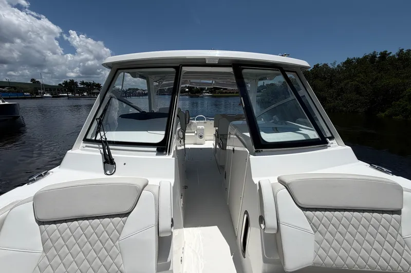 Slide: The Image of 2027 World Cat 325 DC boat interior with luxurious seating on a sunny day. - 20