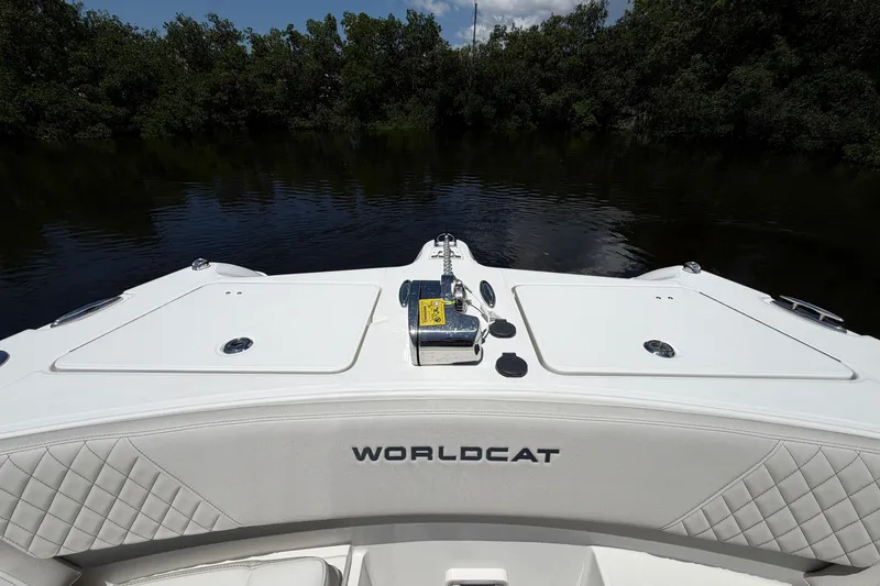 Slide: The Image of 2027 World Cat 325 DC boat on calm water, featuring sleek white deck design. - 19