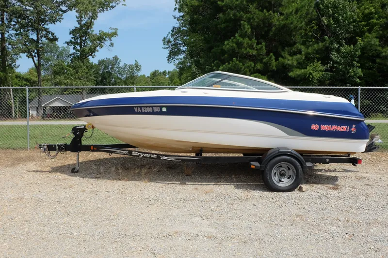 The Image of 2009 Bryant 190 boat on trailer, blue and white, parked outdoors. - 0