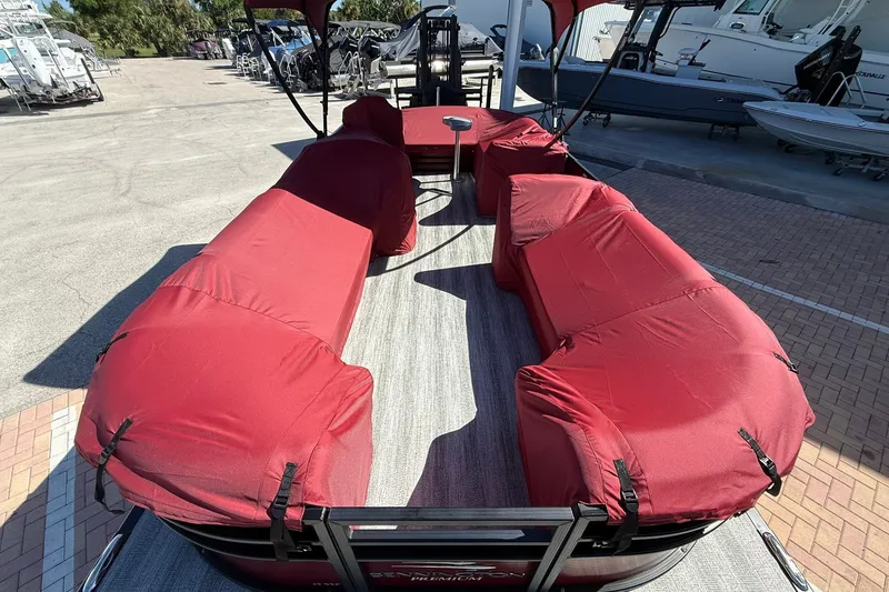 Slide: The Image of 2020 Bennington SXP 25 SSBXP pontoon boat with red covered seating, docked outdoors. - 31