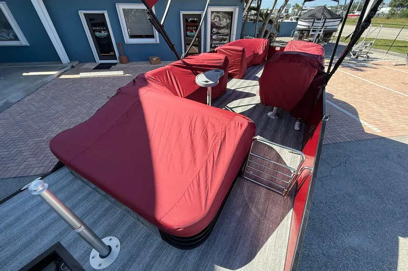 Slide: The Image of 2020 Bennington SXP 25 SSBXP pontoon boat with red covers, docked outdoors. - 13