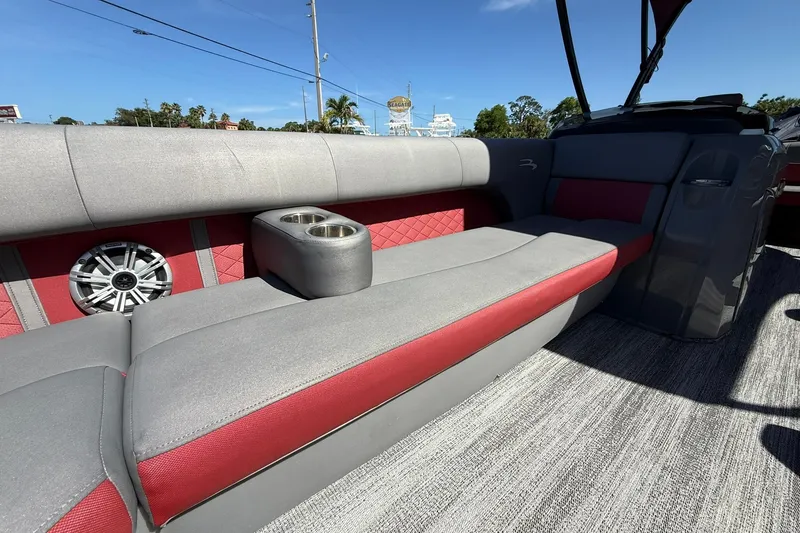 Slide: The Image of 2020 Bennington SXP 25 SSBXP boat interior with gray and red seating, cup holders, and speaker. - 33
