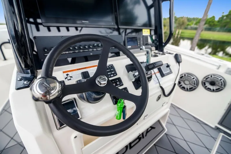 Slide: The Image of 2021 Cobia 280 Center Console boat dashboard with steering wheel and controls. - 18