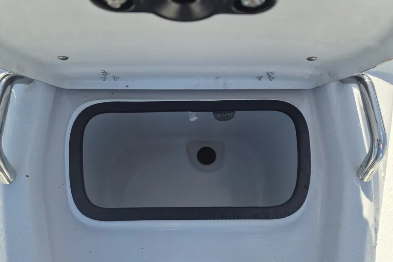 Slide: The Image of Open storage compartment on 2027 Xpress H20 Bay boat, featuring stainless steel handles. - 21