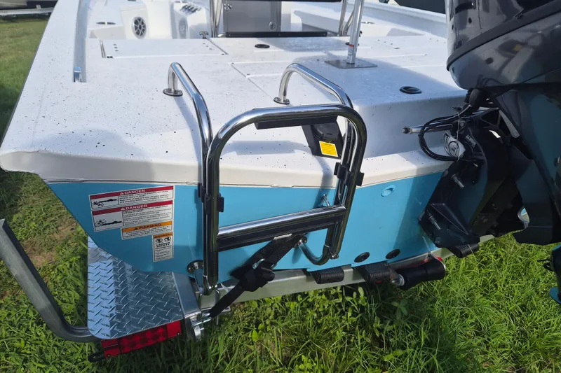 Slide: The Image of 2027 Xpress H20 Bay boat rear view with ladder and motor on grass. - 4