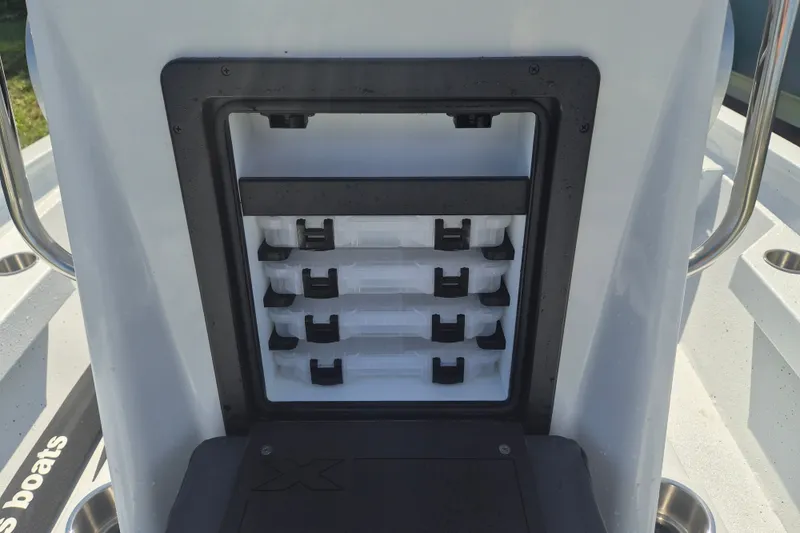 Slide: The Image of 2027 Xpress H20 Bay boat storage compartment with organized tackle boxes. - 20
