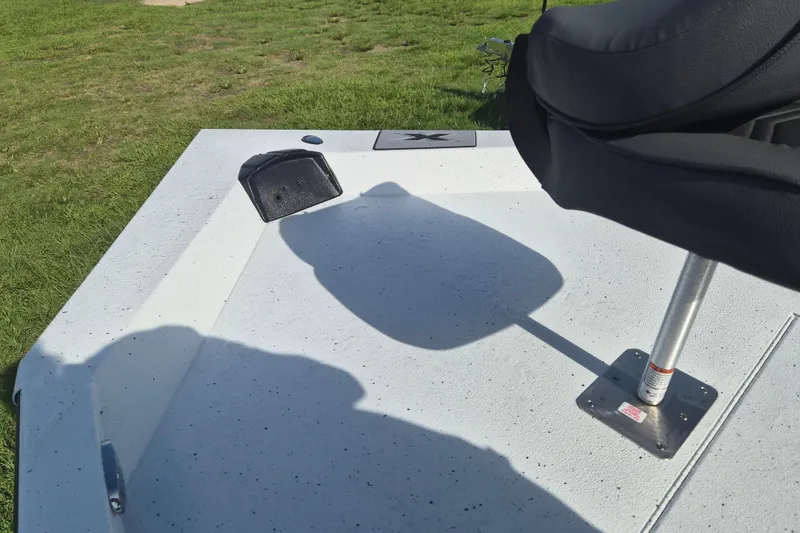 Slide: The Image of 2027 Xpress H20 Bay boat deck with seating and grassy background. - 27