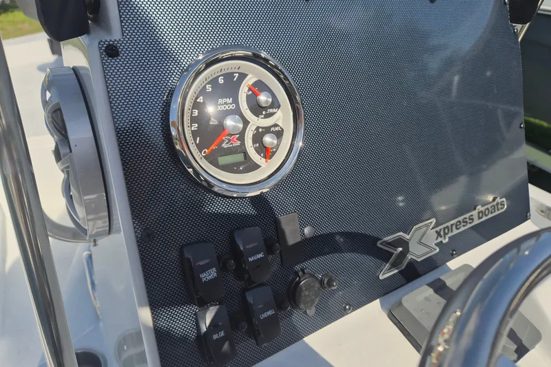 Slide: The Image of Dashboard of 2027 Xpress H20 Bay boat with RPM gauge and control switches. - 13