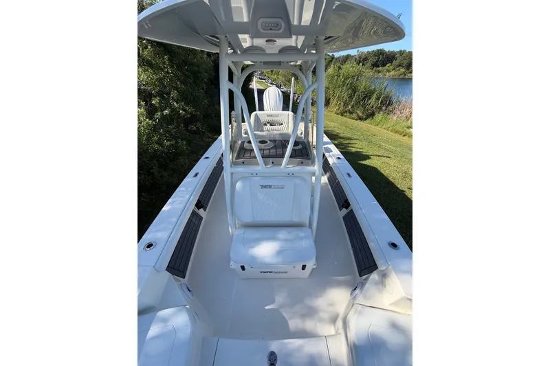 Slide: The Image of 2025 Pathfinder 2400 TRS boat with seating, docked near lush greenery. - 19