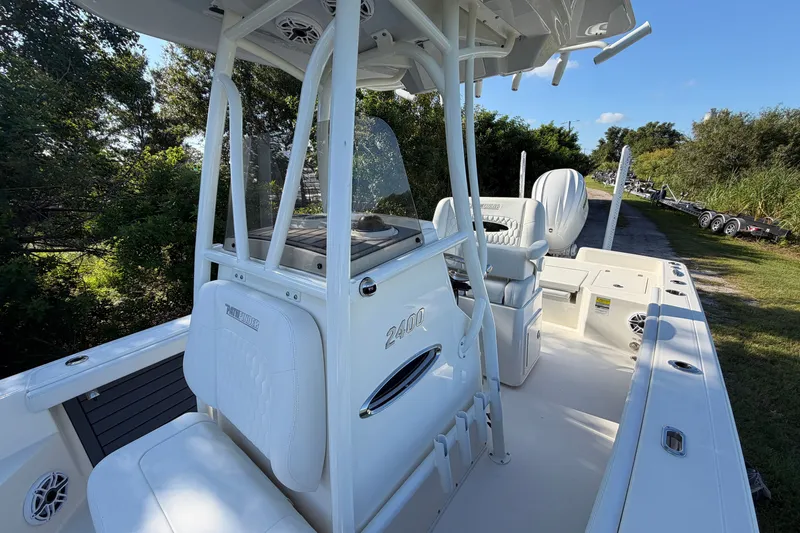 Slide: The Image of 2025 Pathfinder 2400 TRS boat interior with seating and console, surrounded by greenery. - 14
