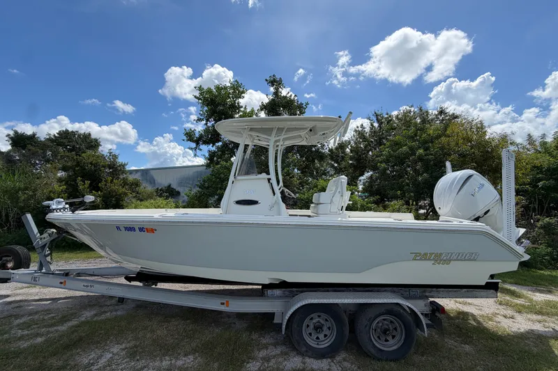 The Image of 2025 Pathfinder 2400 TRS boat on trailer, parked outdoors under a blue sky. - 1