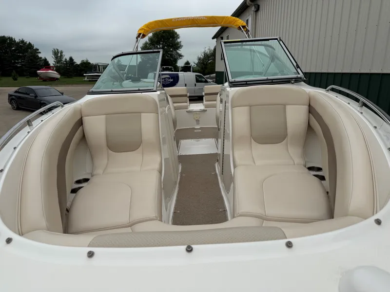 Slide: The Image of 2006 Chaparral SSi 256 with beige seating and yellow bimini top, parked outdoors. - 4